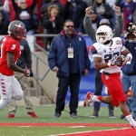 Arizona running back Jared Baker, right, scores a touchdown past New Mexico safety Lee Crosby during the first half of the New Mexico Bowl NCAA college football game in Albuquerque, N.M., Saturday, Dec. 19, 2015. Arizona won 45-37. (AP Photo/Andres Leighton)
