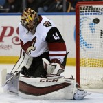 Arizona Coyotes goaltender Mike Smith deflects the puck during the first period of an NHL hockey game against the Buffalo Sabres, Friday, Dec. 4, 2015, in Buffalo, N.Y. (AP Photo/Gary Wiepert)