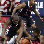 Fresno State center Terrell Carter II, left, Julien Lewis (0) and Sam Bittner, right, battle for the ball with Arizona guard Parker Jackson-Cartwright, middle,  during the first half of an NCAA college basketball game, Wednesday, Dec. 9, 2015, in Tucson, Ariz. (AP Photo/Rick Scuteri)