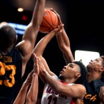 Arizona guard Allonzo Trier (11) drives into the lane between Long Beach State forward Roschon Prince, left, guard A.J. Spencer (15) and guard Nick Faust (2) during the first half of an NCAA college basketball game Tuesday, Dec. 12, 2015, in Tucson, Aria. (Kelly Presnell/Arizona Daily Star via AP)