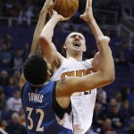 Phoenix Suns' Alex Len, right, of Ukraine, tries to shoot as Minnesota Timberwolves' Karl-Anthony Towns (32) gets a hand on the ball during the first half of an NBA basketball game Sunday, Dec. 13, 2015, in Phoenix. (AP Photo/Ross D. Franklin)