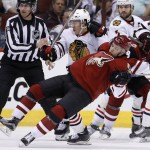Arizona Coyotes' Craig Cunningham, front, gets sent to the ice by Chicago Blackhawks' Teuvo Teravainen, middle, of Finland, as linesman Mark Wheeler (56), Blackhawks' Phillip Danault, right, and Brent Seabrook look for the puck during the first period of an NHL hockey game Tuesday, Dec. 29, 2015, in Glendale, Ariz. (AP Photo/Ross D. Franklin)
