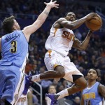 Phoenix Suns' Brandon Knight, right, drives to the basket as Denver Nuggets' Mike Miller (3) defends during the first half of an NBA basketball game Wednesday, Dec. 23, 2015, in Phoenix. (AP Photo/Ross D. Franklin)