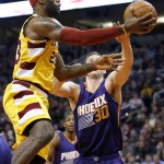 Cleveland Cavaliers' LeBron James, left, gets past Phoenix Suns' Jon Leuer, right, for a score during the first half of an NBA basketball game Monday, Dec. 28, 2015, in Phoenix. (AP Photo/Ross D. Franklin)