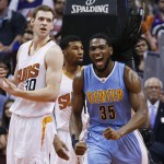 Denver Nuggets' Kenneth Faried (35) shouts after making a basket and being fouled on the play as Phoenix Suns' Jon Leuer (30) and Ronnie Price, center, look to a referee to see who got the foul during the first half of an NBA basketball game Wednesday, Dec. 23, 2015, in Phoenix. (AP Photo/Ross D. Franklin)