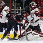 Arizona Coyotes goalie Anders Lindback (29) catches the puck in front of a battling Carolina Hurricanes' Elias Lindholm (16) of Sweden, and Coyote Michael Stone (26) during the first period of an NHL hockey game, Sunday, Dec. 6, 2015, in Raleigh, N.C. (AP Photo/Karl B DeBlaker)