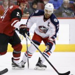 Arizona Coyotes' Kyle Chipchura, left, flips the puck away from Columbus Blue Jackets' Nick Foligno (71) during the first period of an NHL hockey game, Thursday, Dec. 17, 2015, in Glendale, Ariz. (AP Photo/Ross D. Franklin)