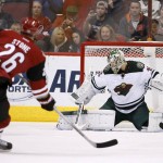 Minnesota Wild's Darcy Kuemper, right, makes a save on a shot by Arizona Coyotes' Michael Stone (26) during the first period of an NHL hockey game Friday, Dec. 11, 2015 in Glendale, Ariz. (AP Photo/Ross D. Franklin)