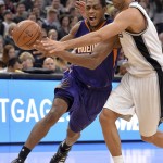 Phoenix Suns guard Brandon Knight, left, tangles with San Antonio Spurs guard Tony Parker, of France, during the first half of an NBA basketball game Wednesday, Dec. 30, 2015, in San Antonio. (AP Photo/Darren Abate)