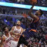 Phoenix Suns' Eric Bledsoe (2), goes up for a shot against Chicago Bulls' Derrick Rose (1), and Joakim Noah (13), during the second half of a basketball game Monday, Dec. 7, 2015, in Chicago. Phoenix won 103-101. (AP Photo/Paul Beaty)