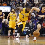 Cleveland Cavaliers' Kyrie Irving (2) steals the basketball from Phoenix Suns' Devin Booker (1) as Cavaliers' Kevin Love (0) and Suns' Alex Len (21) of Ukraine, watch during the first half of an NBA basketball game Monday, Dec. 28, 2015, in Phoenix. (AP Photo/Ross D. Franklin)