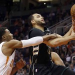 Milwaukee Bucks guard Tyler Ennis, right, gets fouled by Phoenix Suns guard Ronnie Price in the first quarter during an NBA basketball game, Sunday, Dec. 20, 2015, in Phoenix. (AP Photo/Rick Scuteri)
