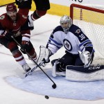 Winnipeg Jets goalie Connor Hellebuyck (30) turns away a shot by Arizona Coyotes left wing Jordan Martinook during the third period during an NHL hockey game, Thursday, Dec. 31, 2015, in Glendale, Ariz. The Coyotes won 4-2. (AP Photo/Rick Scuteri)