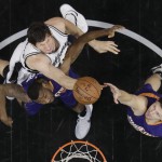 San Antonio Spurs center Boban Marjanovic, top, scores over Phoenix Suns forward Cory Jefferson and forward Mirza Teletovic, right, during the first half of an NBA basketball game, Wednesday, Dec. 30, 2015, in San Antonio. (AP Photo/Eric Gay)