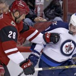 Arizona Coyotes left wing John Scott (28) and Winnipeg Jets center Andrew Copp battle for the puck in the first period during an NHL hockey game, Thiursday, Dec. 31, 2015, in Glendale, Ariz. (AP Photo/Rick Scuteri)