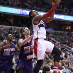 Washington Wizards guard Bradley Beal, right, goes to the basket against Phoenix Suns guard Brandon Knight (3) and Jon Leuer (30) during the second half of an NBA basketball game, Friday, Dec. 4, 2015, in Washington. The Wizards won 109-106. (AP Photo/Nick Wass)