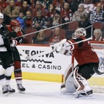 Arizona Coyotes goalie Louis Domingue, right, knocks the puck into the air on a blocker save as Los Angeles Kings' Marian Gaborik (12), of the Czech Republic, and Coyotes' Michael Stone look for a rebound during the second period of an NHL hockey game, Saturday, Dec. 26, 2015, in Glendale, Ariz. (AP Photo/Ralph Freso)