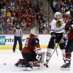 Chicago Blackhawks' Artem Anisimov, center,of Russia, celebrates a goal by Brent Seabrook, as Arizona Coyotes' Anders Lindback (29), of Sweden, and Michael Stone (26) look for the puck during the first period of an NHL hockey game Tuesday, Dec. 29, 2015, in Glendale, Ariz. (AP Photo/Ross D. Franklin)