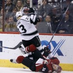 Arizona Coyotes' Klas Dahlbeck (34), of Sweden, falls to the ice as he collides with Los Angeles Kings' Dustin Brown during the second period of an NHL hockey game, Saturday, Dec. 26, 2015, in Glendale, Ariz. (AP Photo/Ralph Freso)