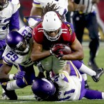 Arizona Cardinals wide receiver Larry Fitzgerald (11) is hit by Minnesota Vikings cornerback Xavier Rhodes (29) and Anthony Harris (41) during the second half of an NFL football game, Thursday, Dec. 10, 2015, in Glendale, Ariz. (AP Photo/Rick Scuteri)