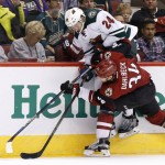 Arizona Coyotes' Klas Dahlbeck (34), of Sweden, shoves Minnesota Wild's Matt Dumba (24) into the boards during the first period of an NHL hockey game Friday, Dec. 11, 2015 in Glendale, Ariz. (AP Photo/Ross D. Franklin)