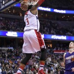 Washington Wizards guard Bradley Beal (3) does a reverse dunk as Phoenix Suns forward Jon Leuer (30) looks on during the second half of an NBA basketball game, Friday, Dec. 4, 2015, in Washington. The Wizards won 109-106. (AP Photo/Nick Wass)