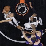 San Antonio Spurs guard Tony Parker (9) is fouled by Phoenix Suns center Alex Len (21) as he drives to the basket during the first half of an NBA basketball game Wednesday, Dec. 30, 2015, in San Antonio. (AP Photo/Eric Gay)