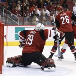 Arizona Coyotes' Anders Lindback (29), of Sweden, gives up a goal to Carolina Hurricanes' Justin Faulk as Hurricanes' Eric Staal (12) and Coyotes' Michael Stone (26) watch during the first period of an NHL hockey game Saturday, Dec. 12, 2015 in Glendale, Ariz. (AP Photo/Ross D. Franklin)