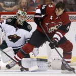 Minnesota Wild's Darcy Kuemper, left, and Arizona Coyotes' Antoine Vermette (50) look for the puck as it bounces along the ice in front of the Wild goalie during the first period of an NHL hockey game Friday, Dec. 11, 2015, in Glendale, Ariz. (AP Photo/Ross D. Franklin)