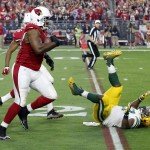 Arizona Cardinals defensive end Cory Redding (90) runs in a fumble recovery for a touchdown as Green Bay Packers running back Eddie Lacy (27) falls to the turf during the second half of an NFL football game, Sunday, Dec. 27, 2015, in Glendale, Ariz. (AP Photo/Ross D. Franklin)