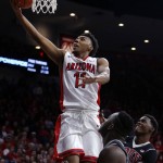 Arizona guard Allonzo Trier (11) drives past two UNLV defenders during the second half of an NCAA college basketball game, Saturday, Dec. 19, 2015, in Tucson, Ariz. Arizona defeated UNLV 82-70. (AP Photo/Rick Scuteri)