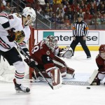 Chicago Blackhawks' Artem Anisimov, left, of Russia, has his shot stopped by Arizona Coyotes' Anders Lindback (29) and Michael Stone (26) during the first period of an NHL hockey game Tuesday, Dec. 29, 2015, in Glendale, Ariz. (AP Photo/Ross D. Franklin)