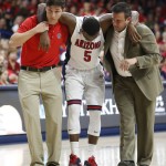 Arizona guard Kadeem Allen (5) is helped off the court with trainers during the first half of an NCAA college basketball game against Fresno State, Wednesday, Dec. 9, 2015, in Tucson, Ariz. (AP Photo/Rick Scuteri)