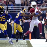 Arizona Cardinals wide receiver Larry Fitzgerald, right, is pushed out of bounds by St. Louis Rams cornerback Lamarcus Joyner, center, after catching a pass for a 23-yard gain as Rams' William Hayes, left, watches, during the second quarter of an NFL football game on Sunday, Dec. 6, 2015, in St. Louis. (AP Photo/L.G. Patterson)