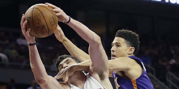 Phoenix Suns guard Devin Booker, right, fouls Detroit Pistons forward Ersan Ilyasova (23) during th...