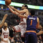 Chicago Bulls' Kirk Hinrich (12), goes up for a shot against Phoenix Suns' Devin Booker (1),  during the first half of a basketball game Monday, Dec. 7, 2015, in Chicago. (AP Photo/Paul Beaty)