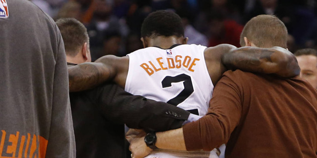 Phoenix Suns guard Eric Bledsoe (2) is helped off the court in the second quarter during an NBA bas...