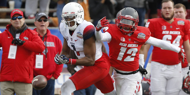 Arizona wide receiver Cayleb Jones, left, misses a reception as he's defended by New Mexico safety ...