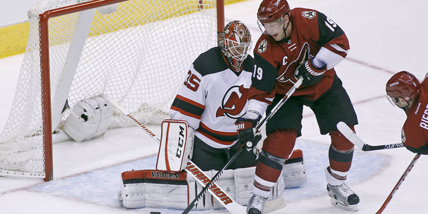Arizona Coyotes' Shane Doan (19) tries to backhand the puck around the pad of New Jersey Devils goa...