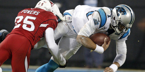 Carolina Panthers' Cam Newton, right, is tackled by Arizona Cardinals' Jerraud Powers, left, in the...