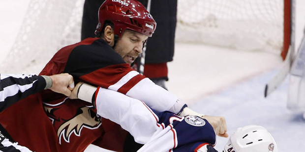Arizona Coyotes' John Scott, left, punches Columbus Blue Jackets' Jared Boll (40) during a fight in...