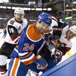 Arizona Coyotes' Shane Doan (19) and Jordan Martinook (48) battle for the puck with Edmonton Oilers' Brad Hunt (24) during first period NHL action in Edmonton, on Saturday, Jan. 2, 2016. (Jason Franson/The Canadian Press via AP)