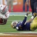 Ohio State wide receiver Braxton Miller (1) falls after being hit by Notre Dame safety Elijah Shumate (22) during the first half of the Fiesta Bowl NCAA College football game, Friday, Jan. 1, 2016, in Glendale, Ariz.  (AP Photo/Rick Scuteri)