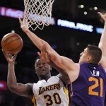 Los Angeles Lakers forward Julius Randle, left, shoots as Phoenix Suns center Alex Len, of Ukraine, defends during the first half of an NBA basketball game, Sunday, Jan. 3, 2016, in Los Angeles. (AP Photo/Mark J. Terrill)