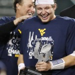 West Virginia's Skyler Howard, right, holds the Offensive Player Of The Game trophy as head coach Dana Holgorsen, left, slaps Howard's shoulder after the Cactus Bowl NCAA college football game against Arizona State, Sunday, Jan. 3, 2016, in Phoenix. West Virginia won 43-42. (AP Photo/Ross D. Franklin)