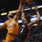 Miami Heat forward Chris Bosh (1) draws the foul on Phoenix Suns forward Markieff Morris during the second quarter of an NBA basketball game, Friday, Jan. 8, 2016, in Phoenix. (AP Photo/Rick Scuteri)