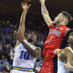 UCLA guard Isaac Hamilton, left, shoots as Arizona guard Gabe York defends during the second half of an NCAA college basketball game, Thursday, Jan. 7, 2016, in Los Angeles. UCLA won 87-84. (AP Photo/Mark J. Terrill)