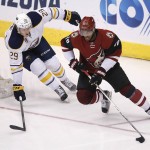 Arizona Coyotes left wing Anthony Duclair (10) shields the puck from Buffalo Sabres defenseman Jake McCabe in the third period during an NHL hockey game, Monday, Jan. 18, 2016, in Glendale, Ariz. (AP Photo/Rick Scuteri)