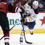 Buffalo Sabres left wing Johan Larsson (22) shoots in front of Arizona Coyotes defenseman Nicklas Grossmann in the first period during an NHL hockey game Monday, Jan. 18, 2016, in Glendale, Ariz. (AP Photo/Rick Scuteri)