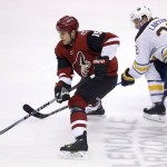 Arizona Coyotes center Boyd Gordon (15) shields the puck from Buffalo Sabres left wing Johan Larsson in the second period during an NHL hockey game, Monday, Jan. 18, 2016, in Glendale, Ariz. (AP Photo/Rick Scuteri)